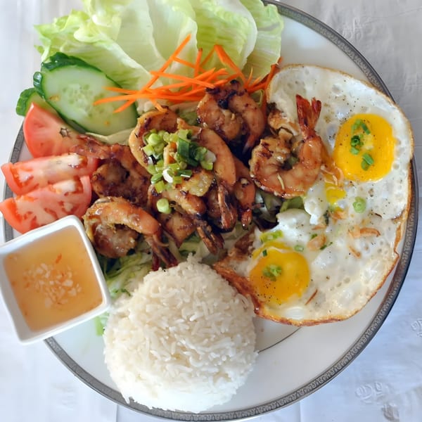 Thai grilled shrimp with fried eggs, rice, fresh vegetables, and dipping sauce.